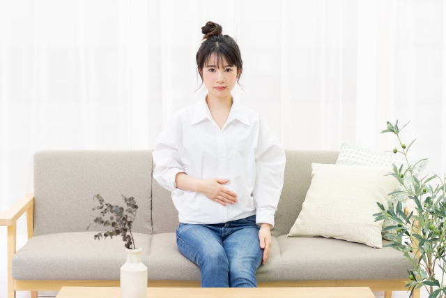 お腹を押さえる女性