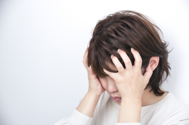 不調で苦しむ女性