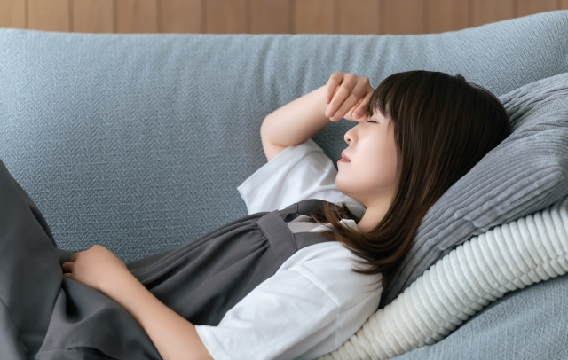生理痛で寝込む女性